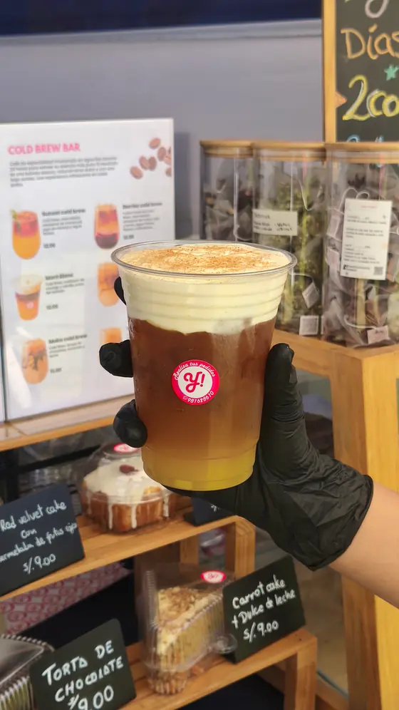 Cold brew para llevar sostenido frente a la carta del Cold Brew Bar