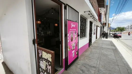 Fachada de Yummy en la Av. Atahualpa, con la puerta abierta y el banner rosa de la carta